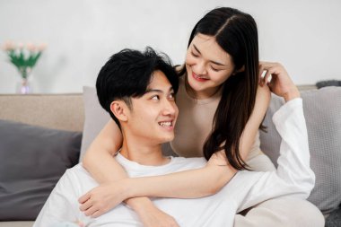 Bir çiftin, partnerinin kulağına şakacı bir şekilde dokunarak birbirlerine yakınlık gösterdikleri şefkatli bir gülüşü paylaştığı sevgi dolu bir sahne..