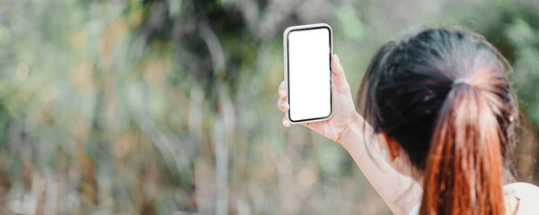 Person holding up a smartphone with a blank screen ready for content placement.