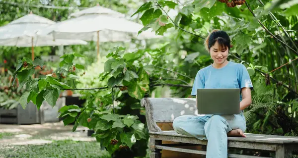 Молода Жінка Посміхається Коли Працює Ноутбуці Сидить Дерев Яній Лавці Стокове Фото