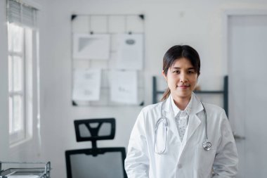 Modern bir muayenehanede beyaz önlük ve steteskop giymiş, kendine güvenen profesyonel bir kadın doktor..