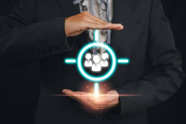 Müşterileri hedeflemek için dijital arayüz kullanan takım elbiseli bir işadamı, pazarlama stratejilerini ve müşteri segmentasyonunu sembolize ediyor.