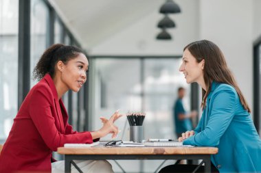 İki kadın, modern bir ofiste profesyonel bir iş görüşmesinde büyük pencereleri ve doğal ışığı olan iki kadın..