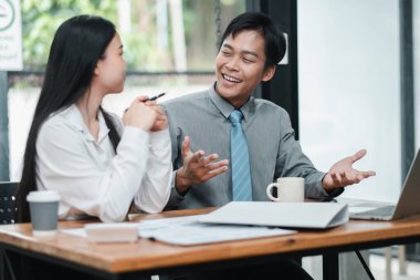 İki meslektaş, modern ofis ortamında fikir ve stratejileri tartışan verimli bir iş toplantısı yaptılar..