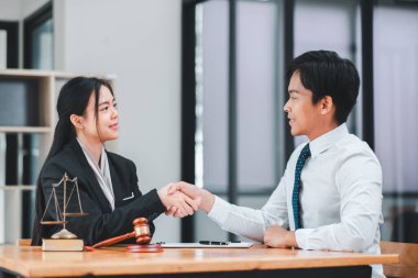 Modern bir ofiste el sıkışan iki iş adamı, anlaşma ve ortaklığı simgeliyor..