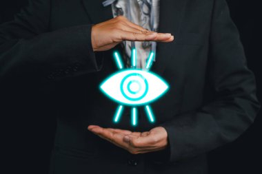 Bir işadamı, modern bir iş ortamında gelecekteki vizyon, yenilik ve anlayışı temsil eden parlak bir göz sembolüne sahiptir..