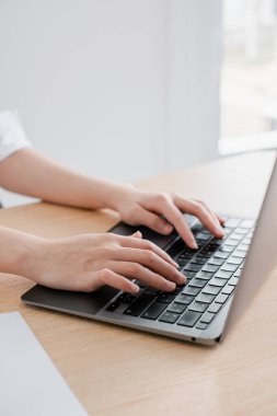 Eller dizüstü bilgisayarda, modern ofis ortamında, teknoloji ve verimliliği gösteriyor..