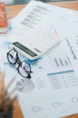 Bir hesap makinesi, gözlük ve pazarlama raporlarının yer aldığı çalışma alanı, finans, iş ve analiz temaları için idealdir.