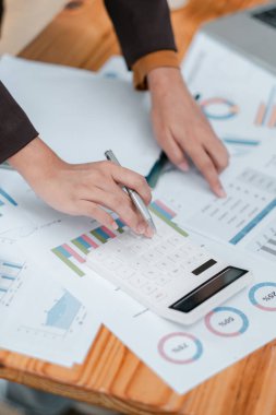 Mali tablolarda bir hesap makinesi kullanarak ellerin yakın plan görüntülenmesi, iş analizi ve veri yönetimi.