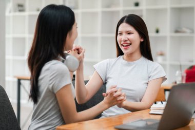 Modern bir ofiste iki genç kadın neşeli bir anı paylaşıyor, sohbet ve kahkahalarla iç içe..