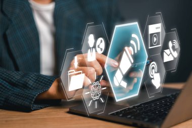 Modern bir iş ortamında eylem kavramına çağrı yapan etkileşimli dijital simgeler ve akıllı telefon.