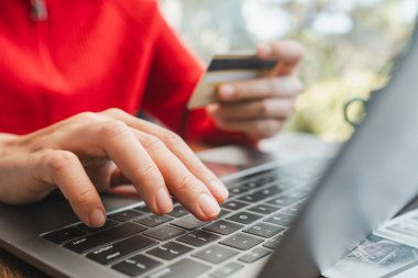 Eller dizüstü bilgisayarda yazarken ve kredi kartı tutarken, online alışveriş ve e-ticareti rahat bir ortamda temsil ederken,.