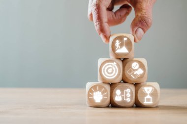 Hedefleri, başarıyı ve takım çalışmasını temsil eden meydan okuma simgeleriyle tahta bloklar. İş ve kişisel gelişim temaları için mükemmel.