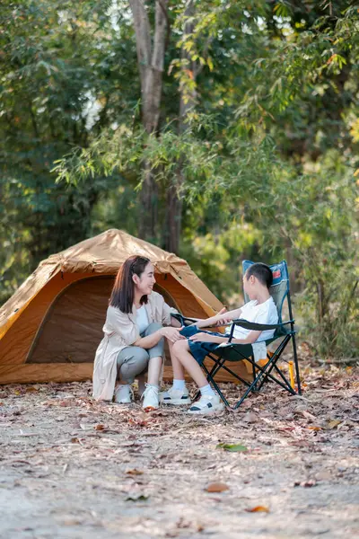 Bir anne ve çocuk kamp gezisi sırasında birbirine bağlanıyor. Arka planda çadır olan doğa ile çevrili..