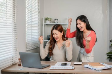 Memleketten çalışan iki kadın, takım çalışması ve başarı sergileyerek başarıyı kutluyor..