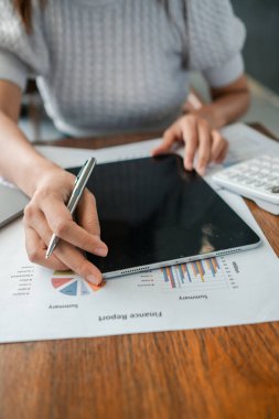 Finansal verileri tablet ve kalemle inceleyen, iş analizini ve teknolojiyi vurgulayan bir kişinin yakın çekimi.