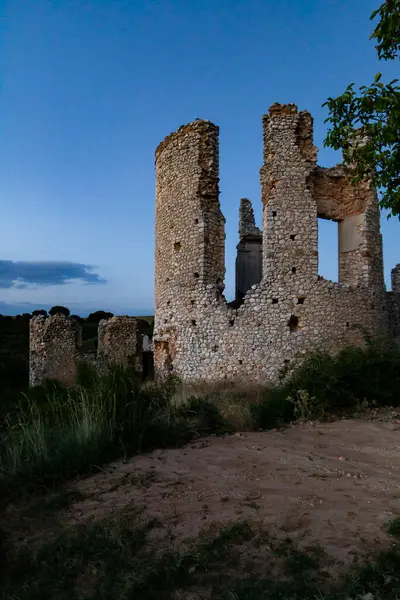 Tarihi bir taş harabe alacakaranlık gökyüzüne karşı dimdik duruyor. Etrafı yeşillik ve gün ışığıyla çevrili..