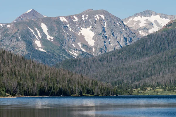 The Never Summer Mountain Range is reflected in the waters of Long Draw Reservoir which is filled by the high peaks which are in Rocky Mountain National Park.