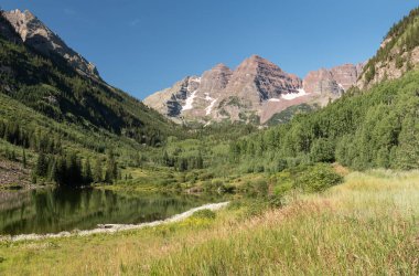 Orta Colorado 'daki Maroon Bells vadisinde güzel bir Ağustos yaz günü. Dünyanın dört bir yanından gelen turistlerin ziyaret ettiği bölgede Kestane Çanları Kar Kütleli Yabanı bulunuyor..