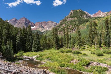 Maroon Creek, Maroon Bells ve Sexton Peak 'in arka planıyla Aspen Colorado' nun güneyindeki West Maroon Trail 'den sabah görüşünde.. 