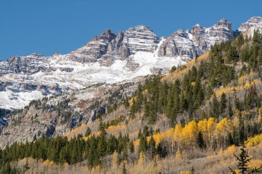 Ashcroft Colorado 'nun hayalet kasabası yakınlarındaki Castle Valley' den görülen engebeli Elk Dağları. Sonbaharın erken saatlerinde yağan kar ve renkli manzara dramatik bir mevsim değişimi yaratır..