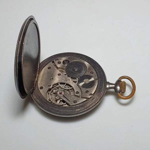 Kapağı açık eski bir cep saati.