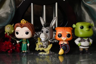 Prenses Fiona, Eşek, Çizmeli Kedi ve Dev Shrek 'in aksiyon figürleri. Sütunları, kırmızı gülleri, yeşil gölgeliği, mermer zemini olan muhteşem bir saray..