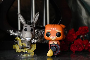 Animasyon filmi Shrek 'ten Donkey ve Çizmeli Kedi' nin aksiyon figürleri. Muhteşem saray, sütunlar, kırmızı güller, yeşil tente, mermer döşeme, yansıma.