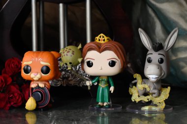 Çizmeli Kedi 'nin Funko Pop aksiyon figürleri, animasyon filmi Shrek' ten Prenses Fiona ve Eşek. Muhteşem saray, sütunlar, kırmızı güller, tente, mermer zemin.