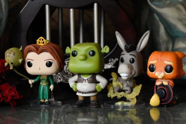 Prenses Fiona, dev Şrek, Eşek ve Çizmeli Kedi 'nin aksiyon figürleri. Sütunları, kırmızı gülleri, yeşil gölgeliği, mermer zemini olan muhteşem bir saray..