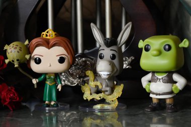 Popüler animasyon filmlerinden Prenses Fiona, Eşek ve Ogre Shrek 'in aksiyon figürleri. Muhteşem saray, sütunlar, kırmızı güller, tente, mermer zemin.