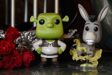 Popüler animasyon filmlerinden Ogre Shrek ve Eşek 'in aksiyon figürleri. Sütunları, kırmızı gülleri, yeşil gölgeliği, mermer zemini olan muhteşem bir saray..
