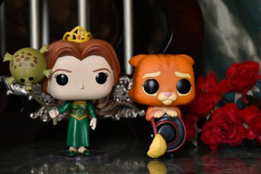 Funko Pop action figures of princess Fiona and Puss in Boots from popular animated film Shrek. Fabulous palace with columns, red roses, canopy, marble floor. clipart