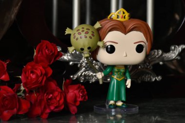 Popüler animasyon filmi Shrek 'ten Prenses Fiona' nın Funko Pop oyuncağı. Sütunları, kırmızı gülleri, kahverengi örtüsü, mermer zemini, yansıması olan muhteşem saray..