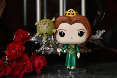Popüler animasyon filmi Shrek 'ten Prenses Fiona' nın Funko Pop oyuncağı. Sütunları, kırmızı gülleri, kahverengi örtüsü, mermer zemini, yansıması olan muhteşem saray..