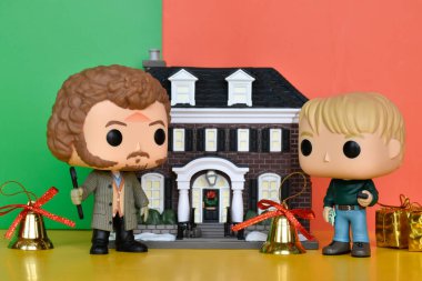 Funko Pop action figures of Kevin with McCallister Home and burglar Marv from comedy film Home Alone. Christmas bells, colorful gift wrappers. clipart