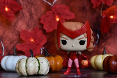 Wanda Vision dizisindeki Cadılar Bayramı kostümlü Marvel süper kahramanı Scarlet Witch 'in funko pop figürü. Renkli balkabakları, kırmızı yapraklar, çelenk ışıkları.