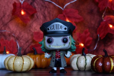 Tim Burton komedi korku filminden Pancar Beetlejuice 'un aksiyon figürü. Cadılar Bayramı dekoru, balkabakları, kırmızı yapraklar, çelenk ışıkları, ürkütücü ruh hali..