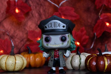 Tim Burton komedi korku filminden Pancar Beetlejuice 'un aksiyon figürü. Cadılar Bayramı dekoru, balkabakları, kırmızı yapraklar, çelenk ışıkları, ürkütücü ruh hali..