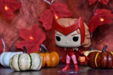 Wanda Vision dizisindeki Cadılar Bayramı kostümlü Marvel süper kahramanı Scarlet Witch 'in funko pop figürü. Renkli balkabakları, kırmızı yapraklar, çelenk ışıkları.