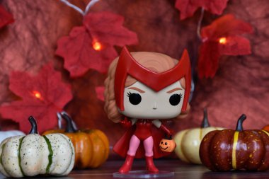Wanda Vision dizisindeki Cadılar Bayramı kostümlü Marvel süper kahramanı Scarlet Witch 'in funko pop figürü. Renkli balkabakları, kırmızı yapraklar, çelenk ışıkları.