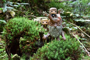 Funko Pop action figure of Treebeard with Merry and Pippin from fantasy movie The Lord of the Rings. Fabulous dense forest, green moss. clipart