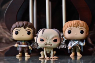 Frodo, Gollum ve Sam 'in fantezi filmi Yüzüklerin Efendisi' ndeki Funko Pop aksiyon figürleri. Sütunları olan karanlık antik saray.