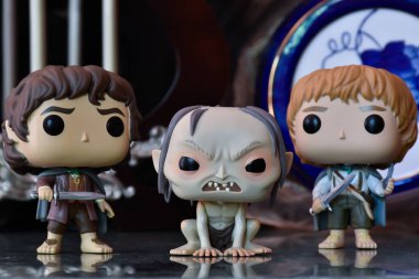 Frodo, Gollum ve Sam 'in fantezi filmi Yüzüklerin Efendisi' ndeki Funko Pop aksiyon figürleri. Sütunları, klasik porselen mavi fıçısı olan eski bir saray..