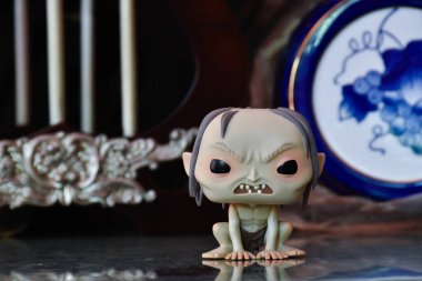 Gollum 'un fantezi filmi Yüzüklerin Efendisi' ndeki Funko Pop figürü. Sütunları, dengesiz arka planı, yansıması, porselen mavi fıçısı olan eski bir saray..