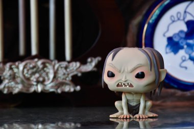 Gollum 'un fantezi filmi Yüzüklerin Efendisi' ndeki Funko Pop figürü. Sütunları, dengesiz arka planı, yansıması, porselen mavi fıçısı olan eski bir saray..
