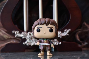 Fantezi filmi Yüzüklerin Efendisi 'ndeki Hobbit Frodo' nun Funko Pop aksiyon figürü. Sütunları olan karanlık antik saray.