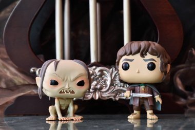 Gollum ve Frodo 'nun fantezi filmi Yüzüklerin Efendisi' ndeki Funko Pop aksiyon figürleri. Köşe yazıları ve dengesiz bir geçmişi olan karanlık antik saray..