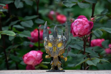 Yüzüklerin Efendisi filmindeki Karanlık Lord Sauron 'un aksiyon figürü Funko Pop. Gizemli karamsar bahçe, kırmızı güller, kasvetli yer.