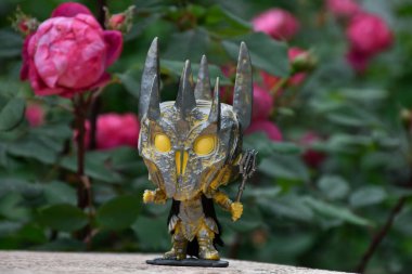 Yüzüklerin Efendisi filmindeki Karanlık Lord Sauron 'un aksiyon figürü Funko Pop. Gizemli karamsar bahçe, kırmızı güller, kasvetli yer.