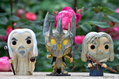 Beyaz Saruman, Sauron ve Yüzüklerin Efendisi 'ndeki Gri Gandalf' ın aksiyon figürleri. Gizemli karamsar bahçe, kırmızı güller.